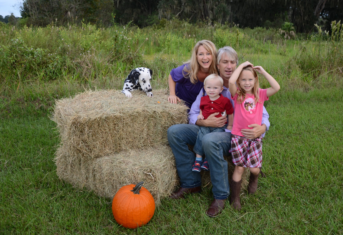 2 large Halloween Hay Bales shown with happy family making memories