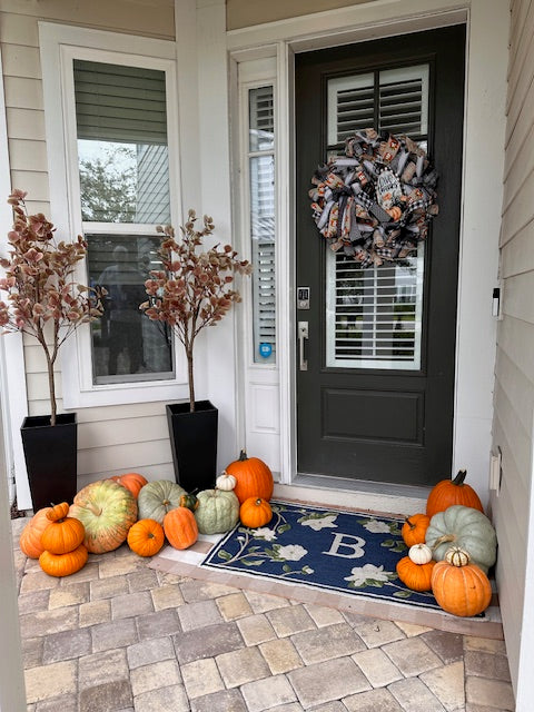 Front door with decorative pumpkins and wreath, on a stone sidewalk in Beachwalk, St. Augustine, FL

